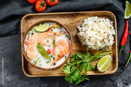 Tom Kha Gai. Spicy creamy coconut soup with chicken and shrimp. Thai food. Black background. Top view