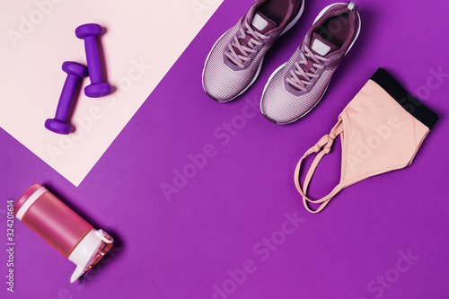 Sports equipment and shoes for women's training. Pink-purple background, diagonal composition. © Aleksandra Abramova