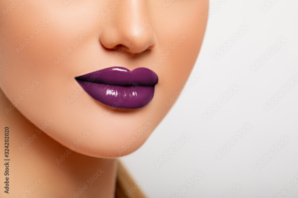 Obraz premium Part Of the Face, Lips Close-up. Colorful lacquer Lipstick of Violet Color. Makeup. Beautiful Advertising Lips with copy space for text or logo 