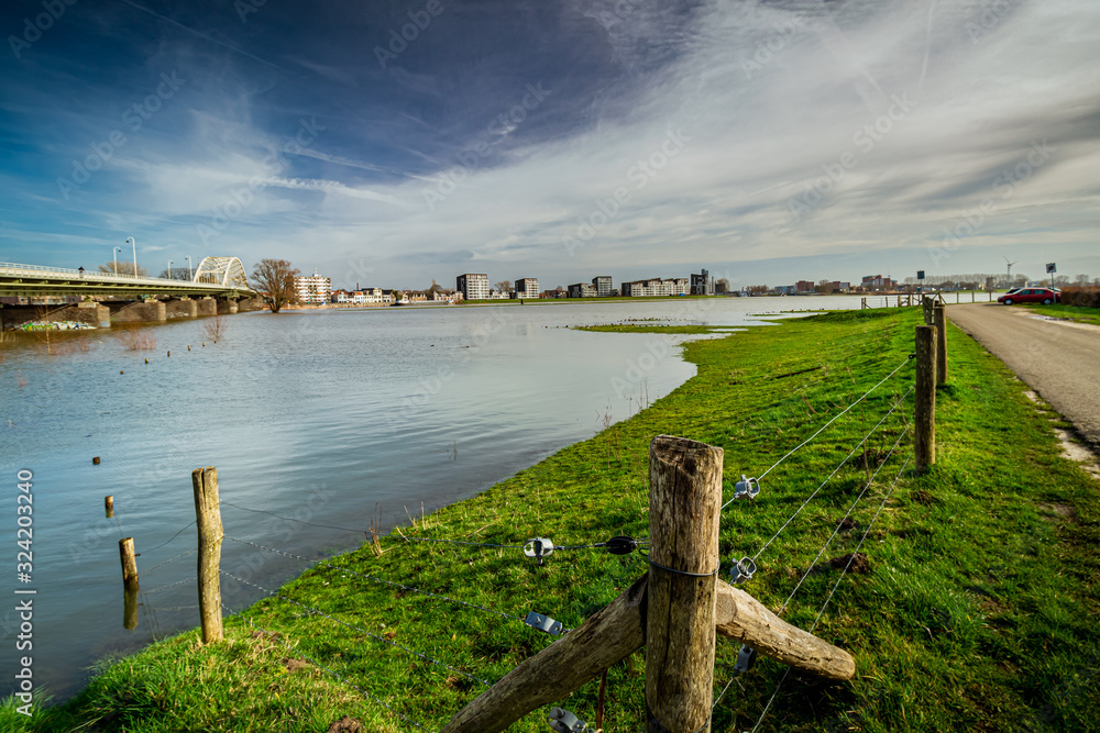 A wooden fence leads you into a flooded meadow in Deventer, the Netherlands