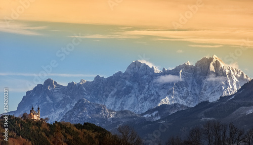 Winter landscape with small church and beautiful high mountains in sunny day, in Styria region, Austria