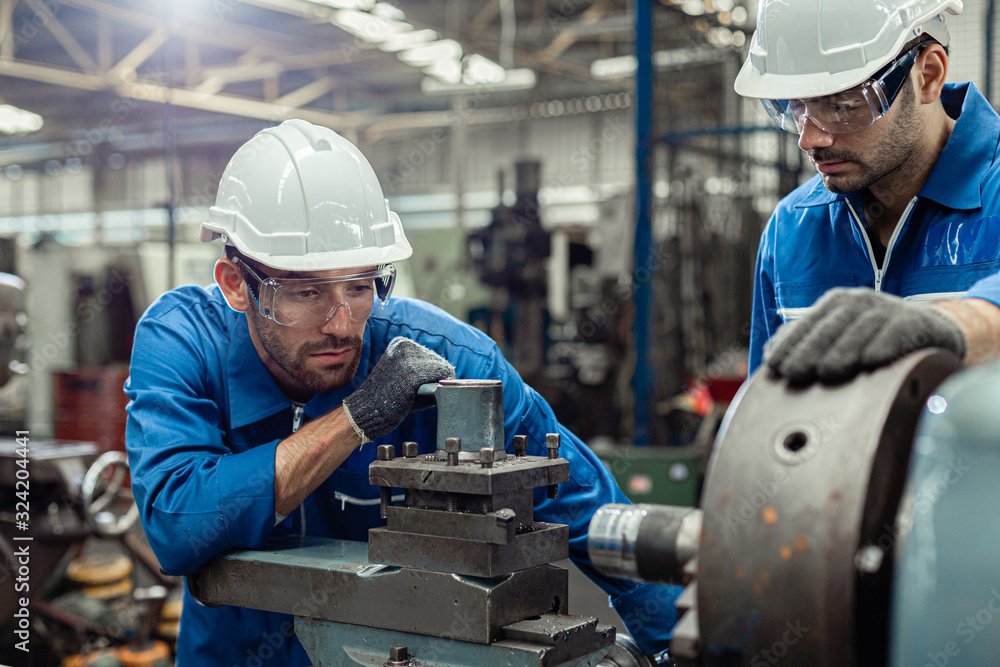 Engineer men wearing uniform safety in factory working machine lathe metal. - obrazy, fototapety, plakaty 