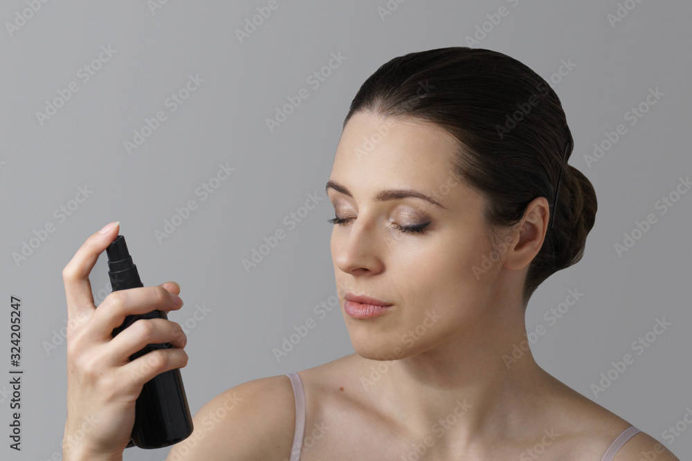 Portrait of woman using spray over her face Portrait of woman using spray over her face
