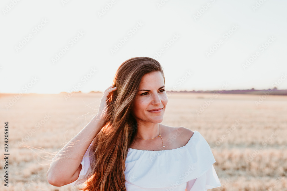 portrait of young beautiful woman on countryside at sunset