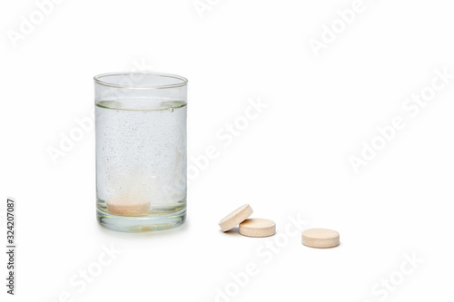 Closeup of effervescent tablets dissolving in a glass of water