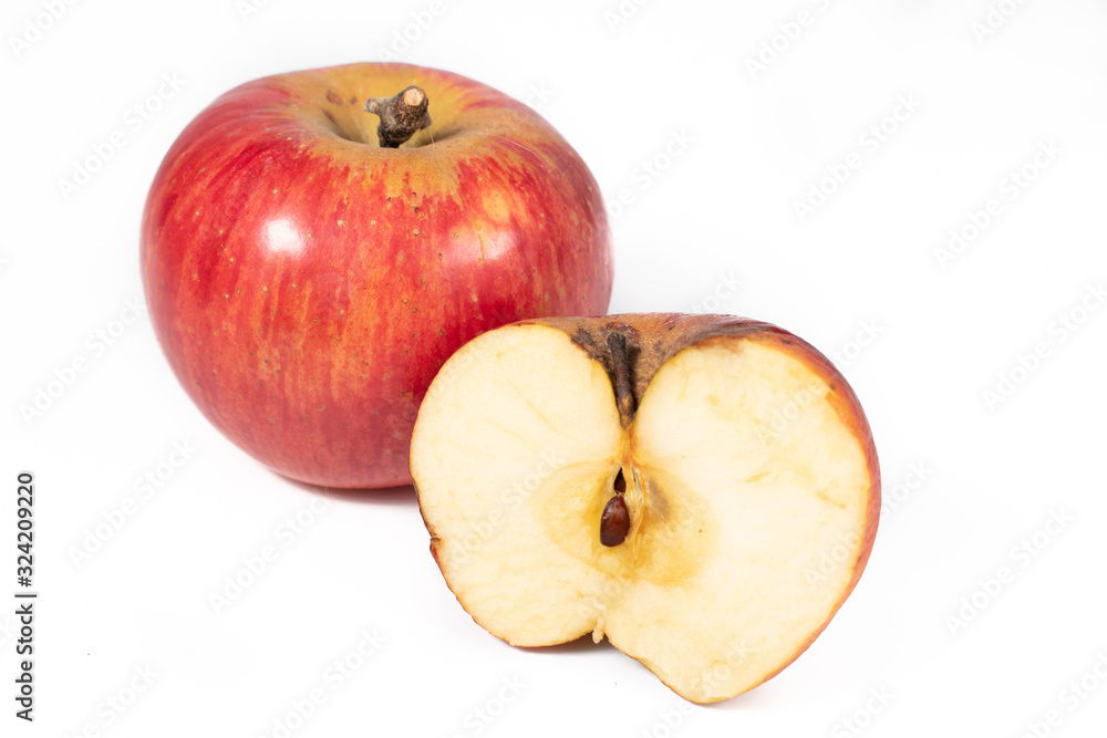 A shiny, whole apple and a half of an apple, on a white background, waiting to be eaten,