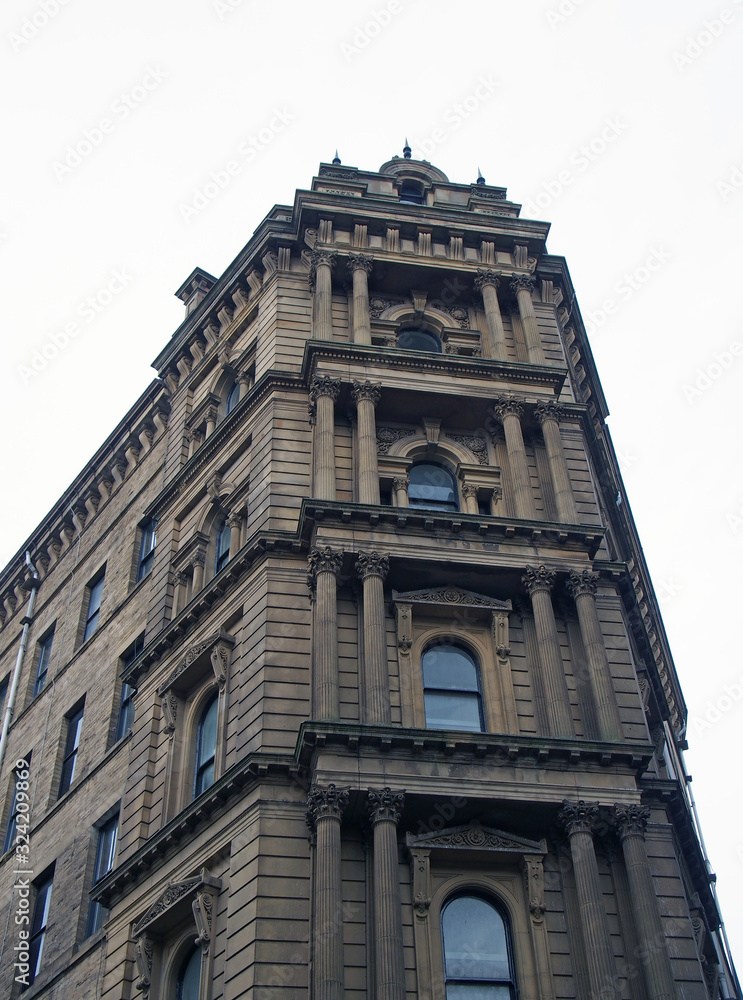 Fototapeta premium perspective view of a 19th century tall stone neoclassical building with ornate columns and windows in the little germany business district of bradford west yorkshire