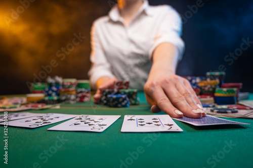 Playing poker in a casino, big bets, a lot of money. Cards, chips. A player plays poker, night club or game club.