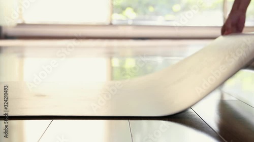 Girl unfolds yoga mat to practise