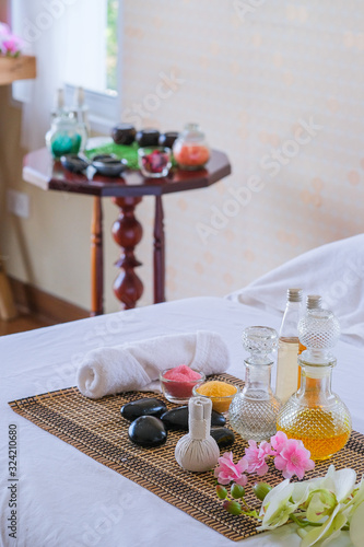 Spa treatment set and aromatic massage oil on bed massage. Thai setting for aroma therapy and massage with flower on the bed, relax and healthy care.