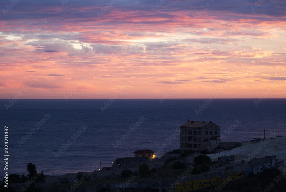 Beautiful sunset and buildings by the sea; placid and deep sea Beautiful sunset and buildings by the sea; placid and deep sea