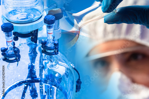 Chemical laboratory. Work with a rotary evaporator. Concept - the use of a rotary evaporator. A man looks at a test tube. Laboratory assistant investigates the result. Lab technician