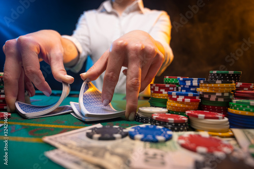 a croupier or a dealer works. A game of cards in a casino. A lot of chips, money. A player in a casino makes bets. Poker