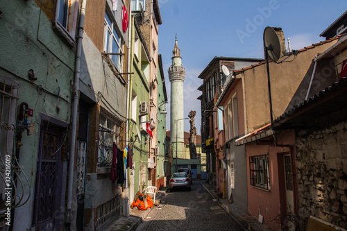 Narrow street in Istanbul's historic district. View of the minaret of the ancient Akbiyik Mosque . Turkey