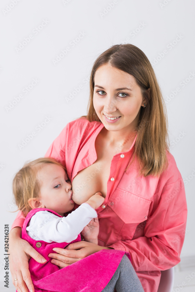 Maternity, breast feeding and infant concept - Mother is breastfeeding her baby daughter Maternity, breast feeding and infant concept - Mother is breastfeeding her baby daughter