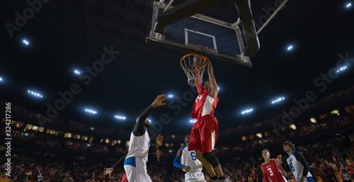 Basketball players on big professional arena during the game. Tense moment of the game. View from below the basket photo
