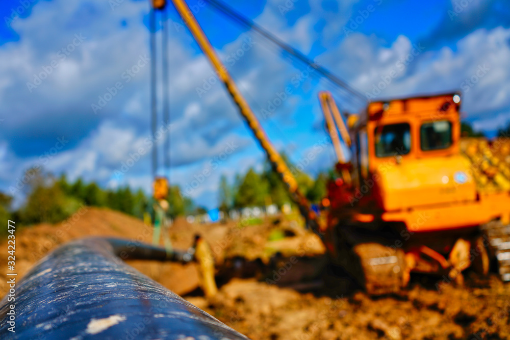 Obraz premium Pipelayer tractor lifts a pipe