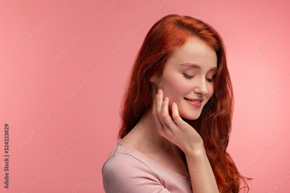 Portrait of smiling redhead girl. Perfect skin. Beautiful female model with long hair over pink background. Young cute woman with clear skin. Skincare and facial treatment concept. Portrait of smiling redhead girl. Perfect skin. Beautiful female model with long hair over pink background. Young cute woman with clear skin. Skincare and facial treatment concept.