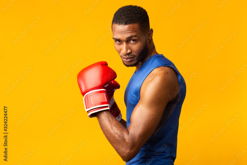 Confident black man wearing red boxing gloves