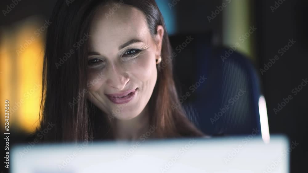 Mysterious positive business woman working on a laptop, inspiration for decision making, received good news, working in the office, close-up. Mysterious positive business woman working on a laptop, inspiration for decision making, received good news, working in the office, close-up.