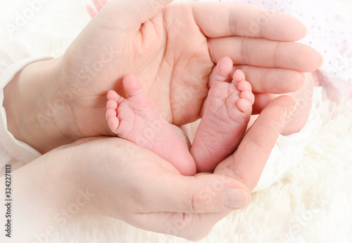 pies de recién nacido cogidos entre las manos de mamá © NATI