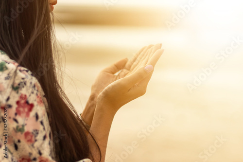 A woman praying hand for blessings When the sun goes down Hope for a happy life Fototapet