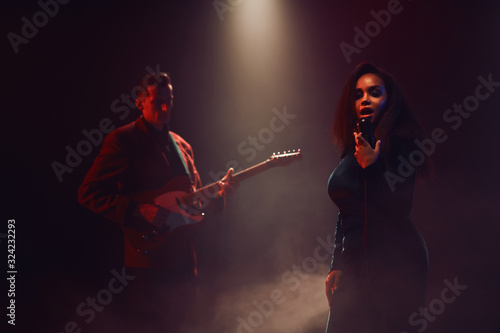 Canvas Print A jazz singer and guitarist perform on stage.
