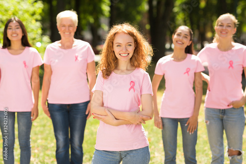 Breast Cancer Volunteer Standing With Group Of Women In Park