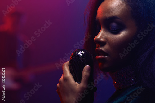 A jazz singer and guitarist perform on stage.