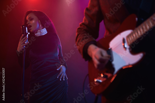 Photography A jazz singer and guitarist perform on stage.