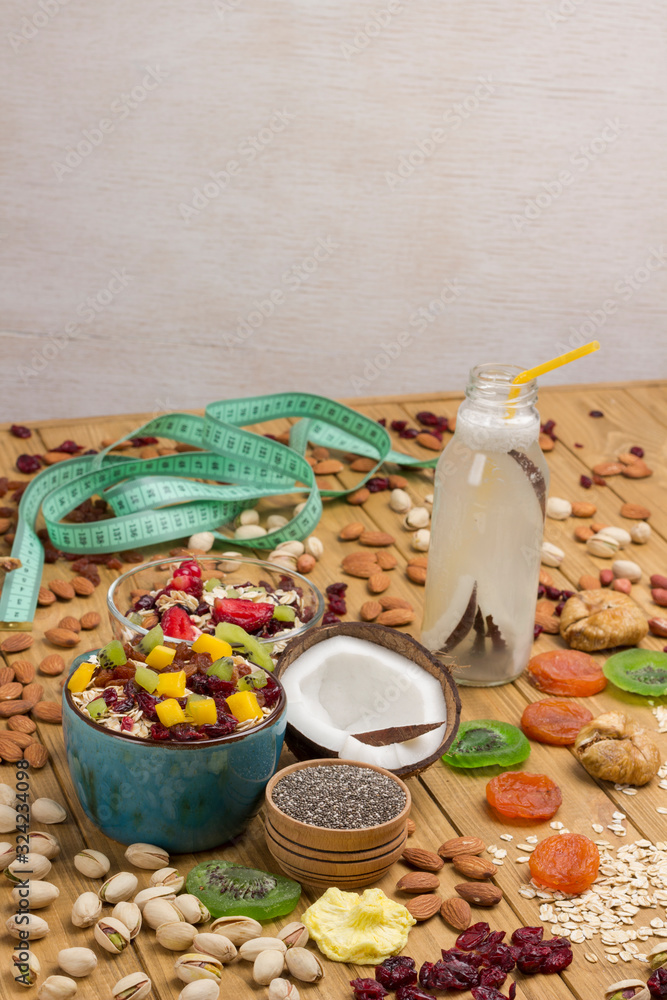 Fototapeta premium Muesli balanced breakfast. Fruits, berries seeds, nuts, coconut beverage, coconut protein vegetarian food