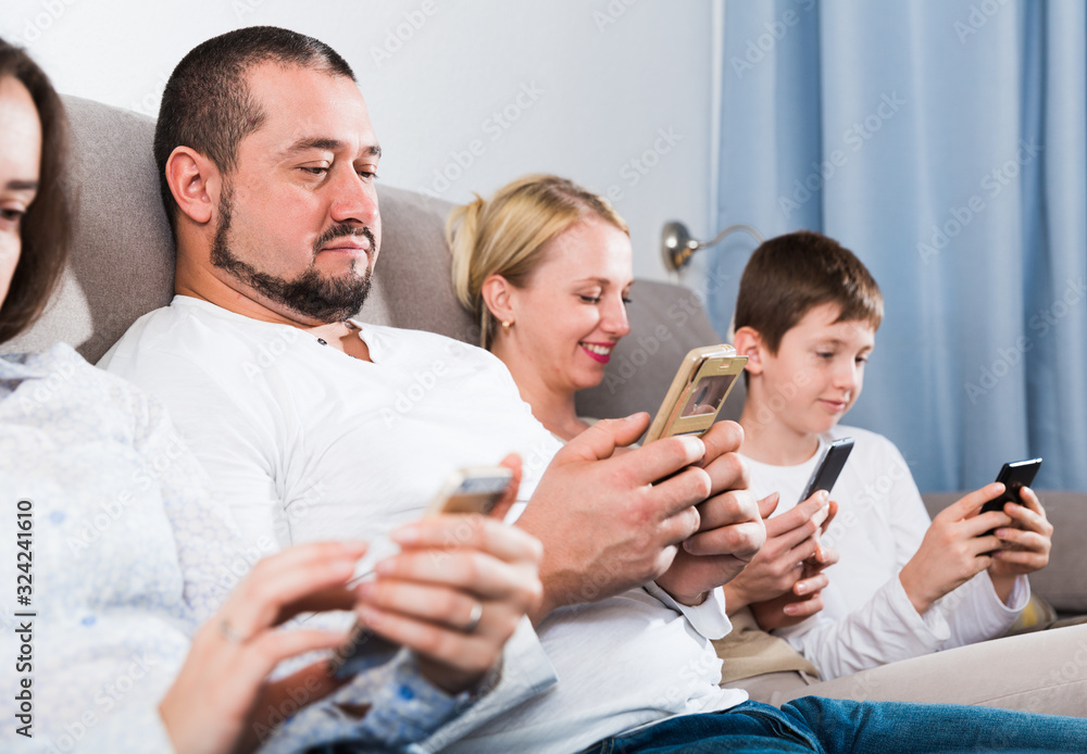 Fotografie Parents with son using mobile gadgets at home