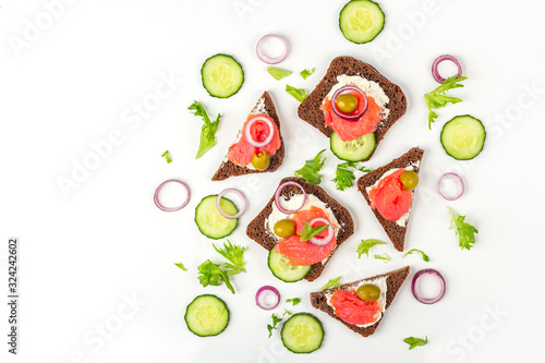 Appetizer  open sandwich with salmon  onion and cucumber on white background. Traditional Italian or Scandinavian cuisine. Concept of proper nutrition and healthy eating. Flat lay  copy space for text