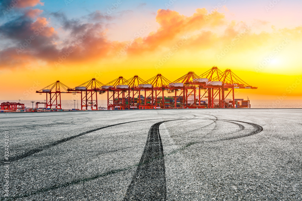Empty race track and industrial container terminal at beautiful sunset in Shanghai.