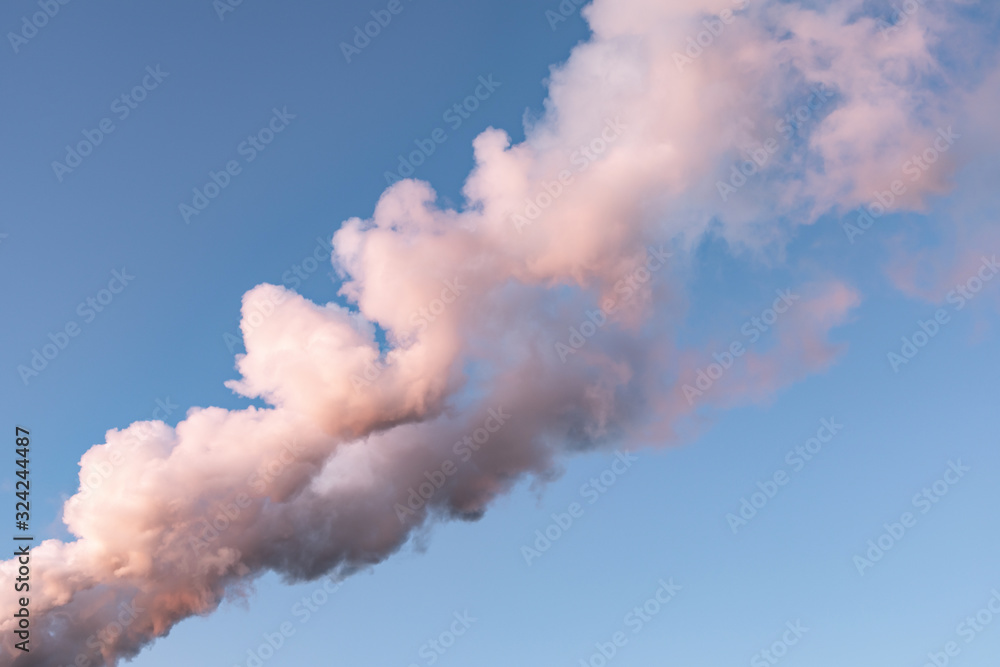 White pink smoke vapor against a clear blue sky. The smoke from the chimney at sunset painted in pink. Air pollution. One smoke for design