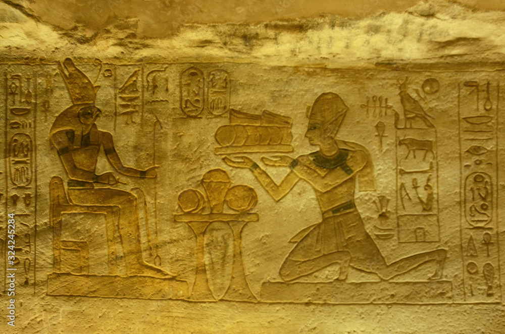 Interior of Abu Simbel with intrigue mural and egyptian hieroglyphs.