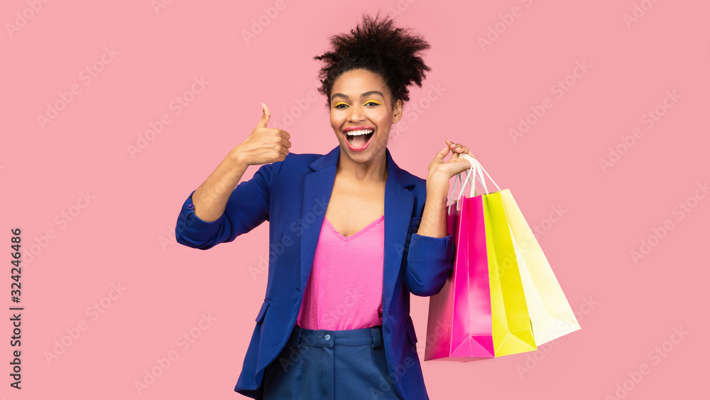 Portrait of smiling afro woman holding shopping bags Portrait of smiling afro woman holding shopping bags