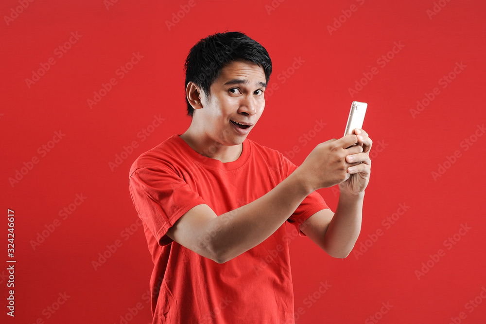 Happy Asian man reading new text on mobile Happy Asian man reading new text on mobile