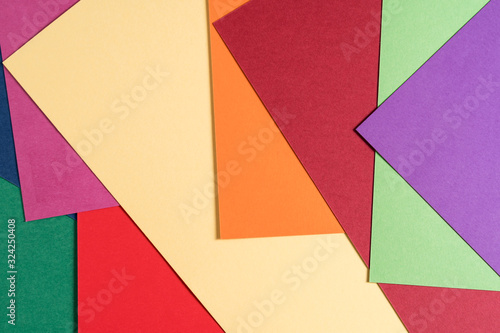 Multi colored abstract paper of pastel colors, with geometric shape, flat lay.