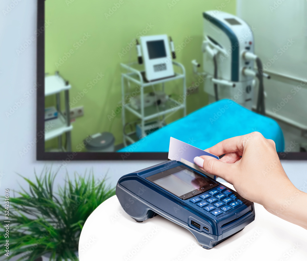 Clinic of aesthetic medicine. Payment by card. Modern payment blue terminal. Clinic of aesthetic medicine. Payment by card. Modern payment blue terminal.