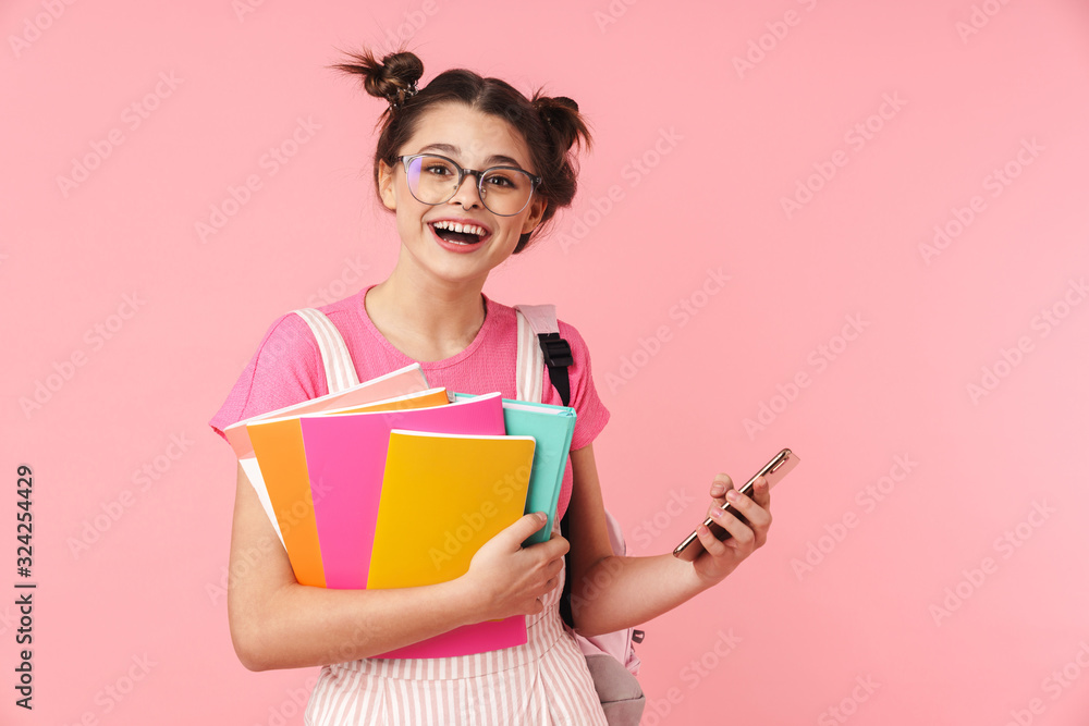 Photo of happy charming girl holding exercise books and using cellphone Photo of happy charming girl holding exercise books and using cellphone