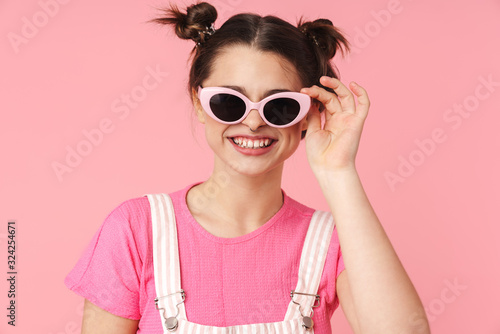 Photo of joyful charming girl in sunglasses posing and smiling
