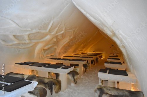 Canvastavla Igloo shaped snow restaurant with carved forest scene walls where all tables and