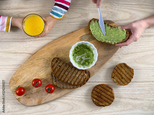 Mother cooking her daughter sandwich with avocado