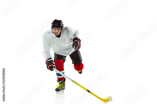 Speed. Young male hockey player with the stick on ice court and white background. Sportsman wearing equipment and helmet practicing. Concept of sport, healthy lifestyle, motion, movement, action.