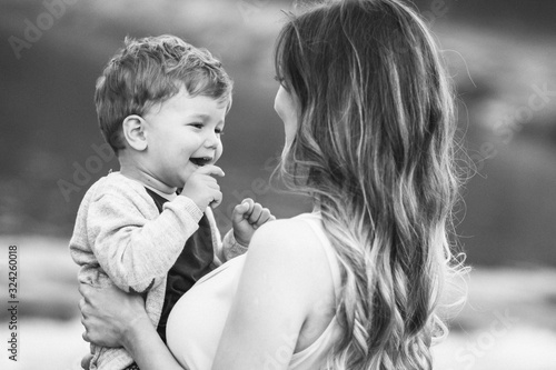 Mom holding her son, looking at him. Black and white photo. Mothers day