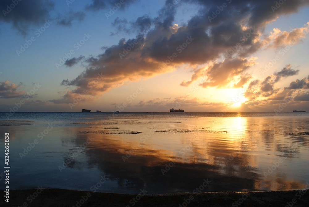 Stunning sunset and gorgeous clouds reflected in the lagoon of Saipan, Northern Mariana Islands.