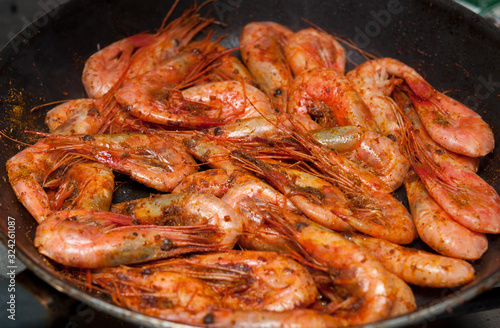Prawns with spices are fried in a pan.
