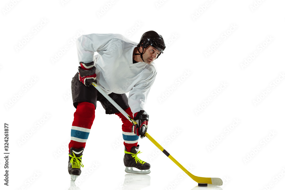 Activity. Young male hockey player with the stick on ice court and white background. Sportsman wearing equipment and helmet practicing. Concept of sport, healthy lifestyle, motion, movement, action. Activity. Young male hockey player with the stick on ice court and white background. Sportsman wearing equipment and helmet practicing. Concept of sport, healthy lifestyle, motion, movement, action.