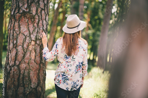 Back of beautiful woman in felt hat walking in park © justesfir